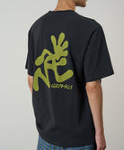 Person wearing a black t-shirt with green graphics and text on the back, standing against a plain background.