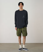 Model wearing a vintage black Gramicci Sticky Hands L/S Tee with a grey frog graphic and olive shorts on a light tone background.