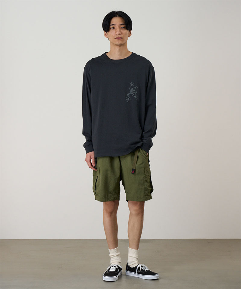 Model wearing a vintage black Gramicci Sticky Hands L/S Tee with a grey frog graphic and olive shorts on a light tone background.