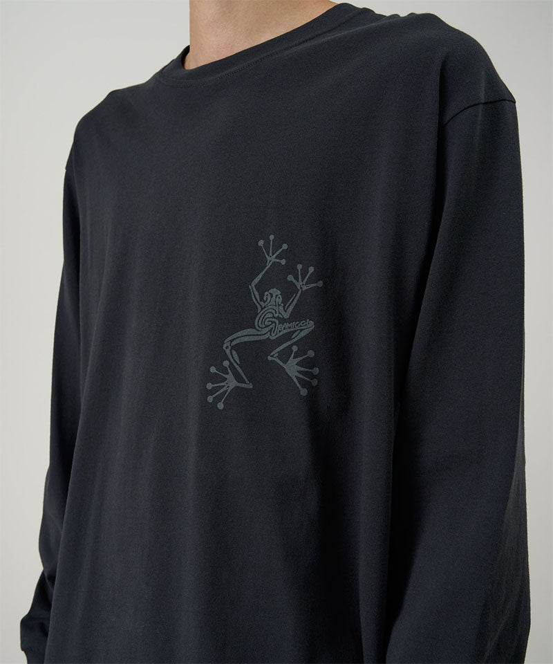 Model wearing a Gramicci vintage black Sticky Hands L/S Tee with grey frog graphic against a light tone background.