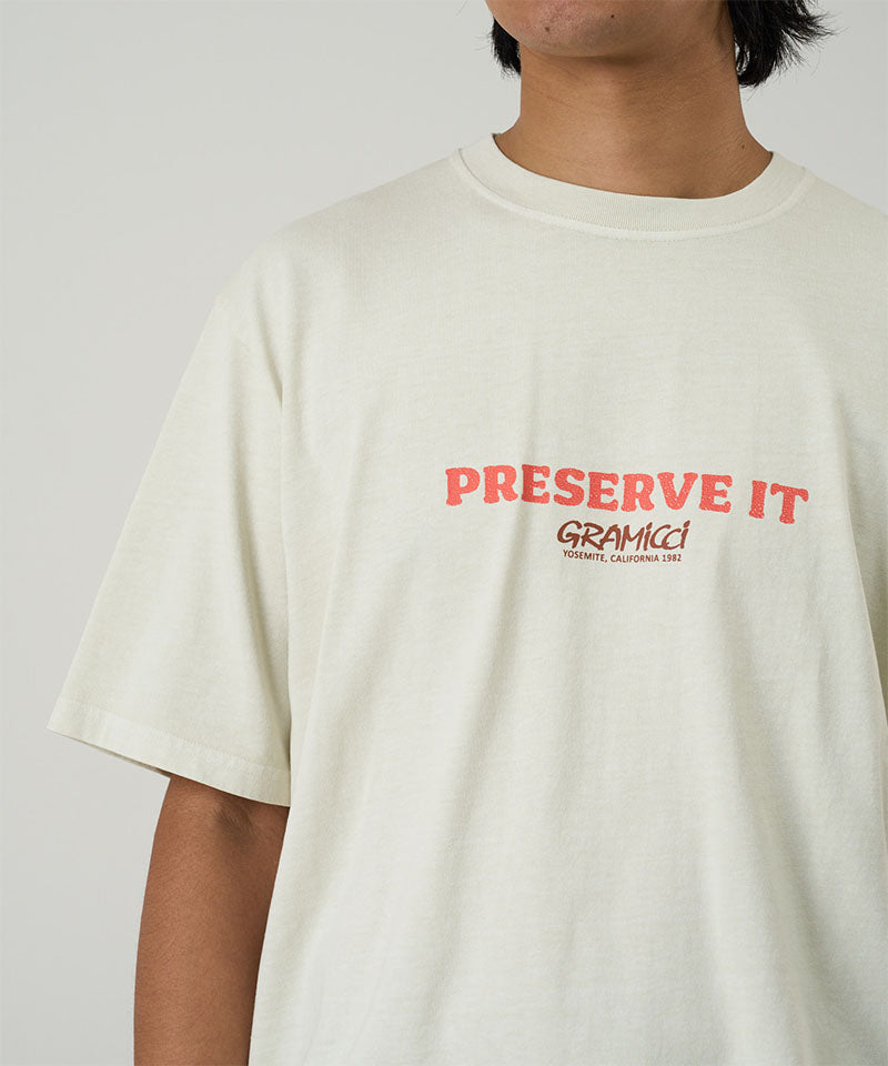 Model wearing a Gramicci natural pigment Footprints Tee Pigment Dyed with red graphic against a light tone background.