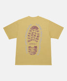 Back view of a Gramicci sulpher yellow Footprints Tee Pigment Dyed with red graphic against a light tone background.