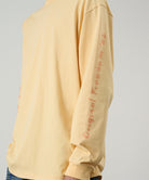 Yellow long-sleeve shirt with text on sleeve against a gray background