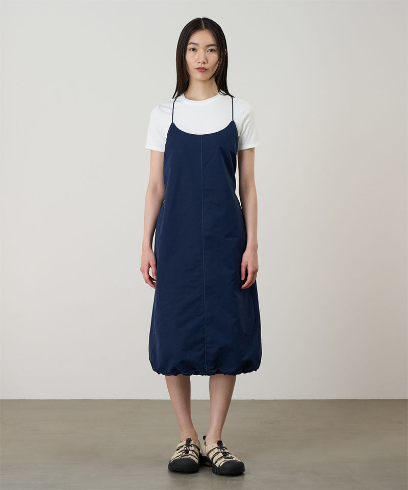 Model wearing a Gramicci Women's Woven Milton Dress in the color dark navy and a white undershirt on a light-tone background.
