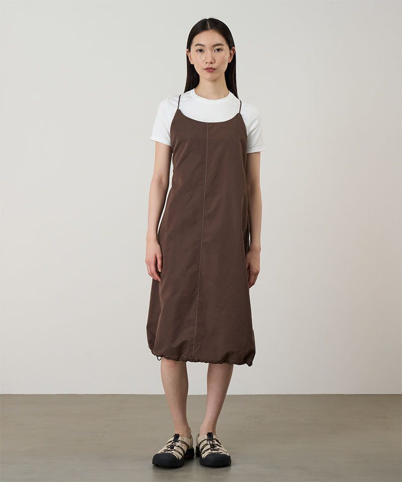 Model wearing a Gramicci Women's Woven Milton Dress in the color walnut and a white undershirt on a light-tone background.
