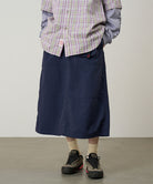 Person wearing a plaid shirt, navy skirt, and hiking shoes on a plain background