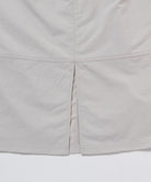 Close-up of a light gray skirt with a white background