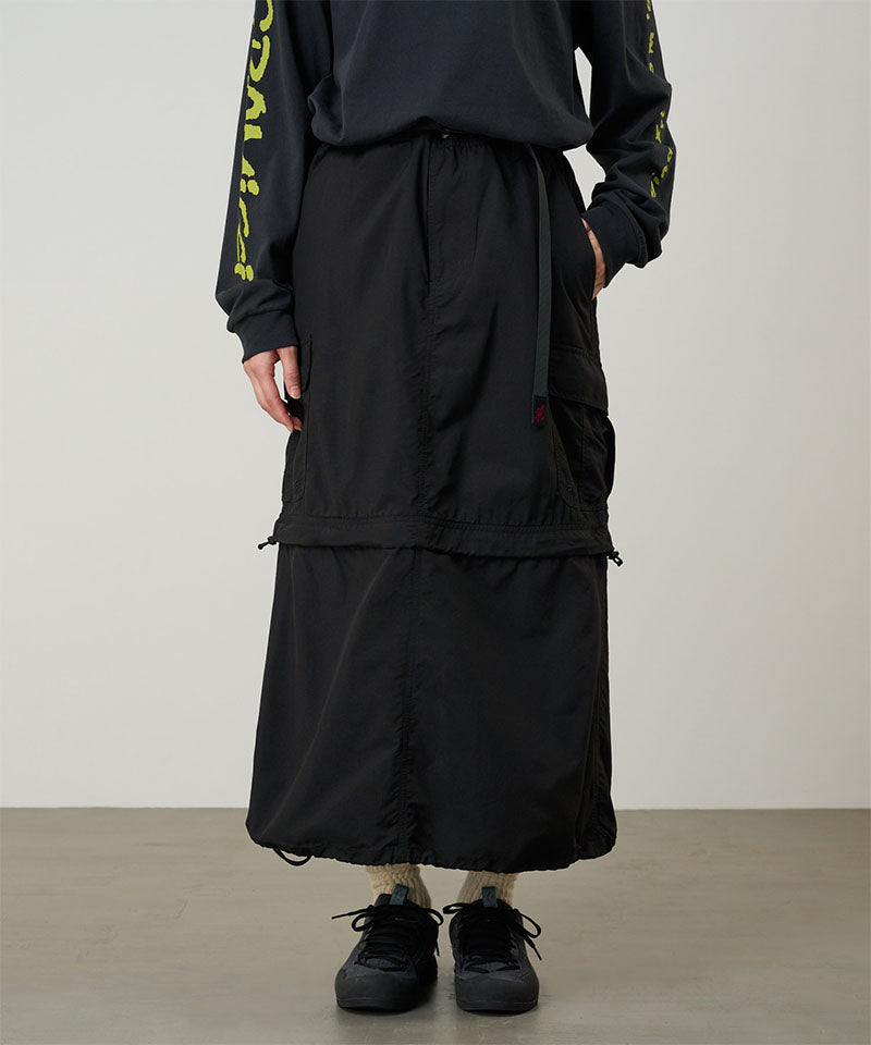 Model wearing a Gramicci Convertible Cargo Skirt in the color black and a black shirt on a light-tone background.