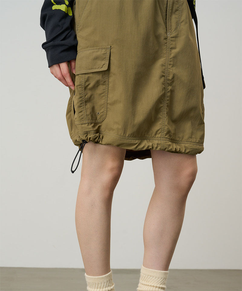 Model wearing a Gramicci Convertible Cargo Skirt in the color khaki on a light-tone background.