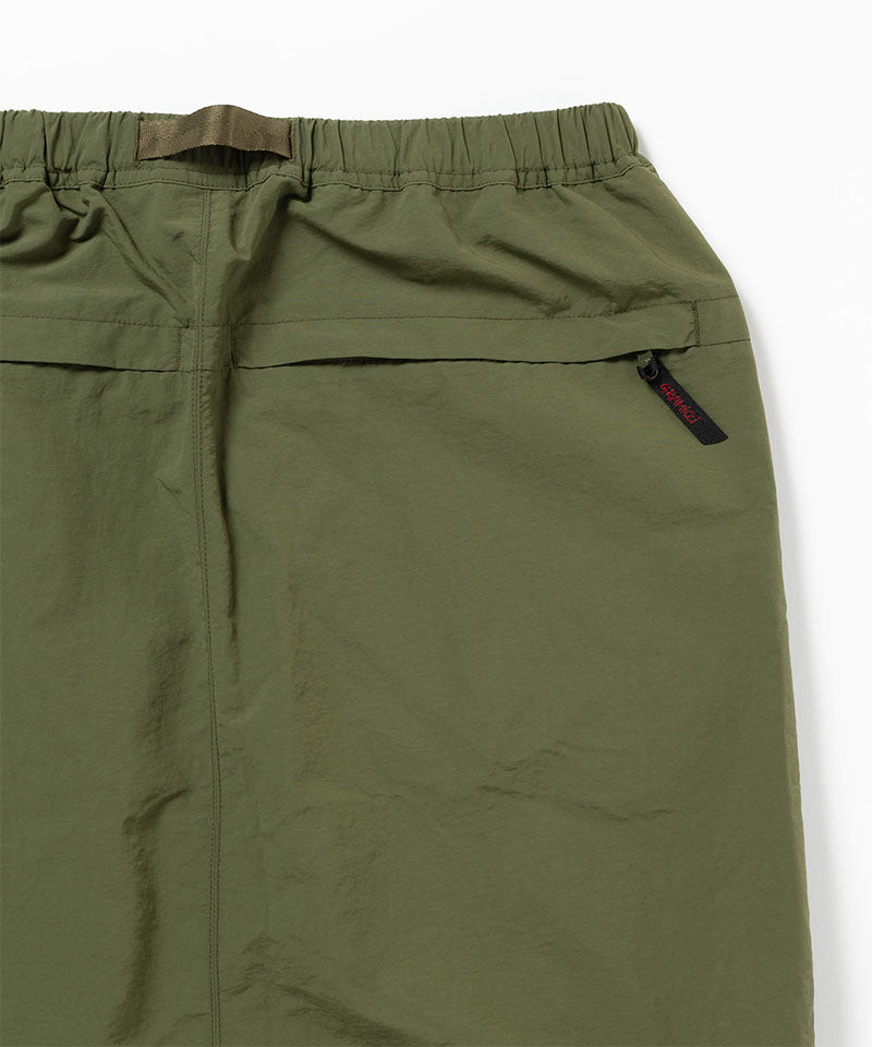 Close-up of a green skirt with a pocket and zipper on a white background