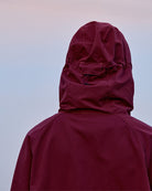 Maroon Gramicci raincoat with hood on a sky background