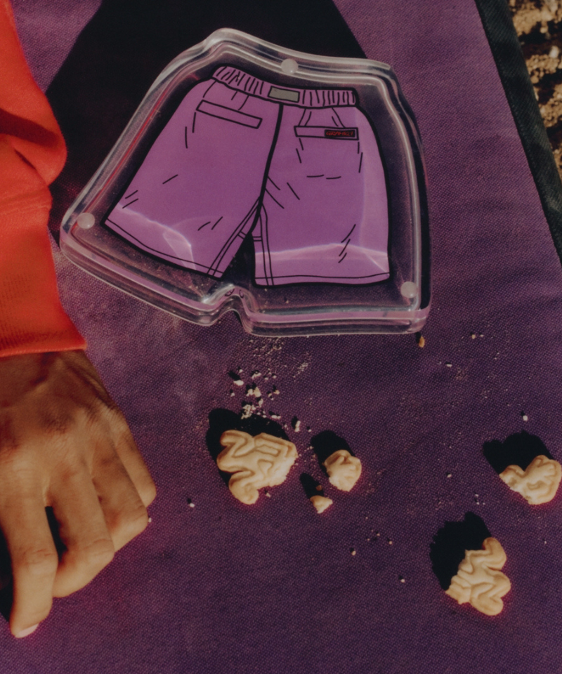 Clear plastic tray with purple shorts design on a purple surface with crumbled cookies.