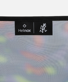 Close-up view of a bright camo Gramici &Helinox Chair One brand tag on a light-tone background.